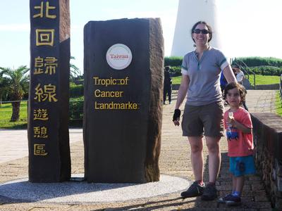 A the Tropic of Cancer "landmarke". <br/> Adam scored his biggest loot of the whole trip here: a fruit seller saw him in the trailer and handed him a cluster of seven small, sweet bananas. Here he is eating #2 or #3.