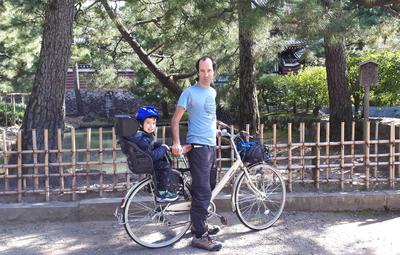 Civilized travel, part 2: exploring Kyoto on two wheels. <br/> This was actually my first time riding with a child seat attached, and Adam's first time in a bicycle child seat. Initially he was not really into it, and was (justifiably) concerned that we might topple over. But it rapidly grew on him, and after that first time he wanted to go everywhere by bike (especially since the alternative was an hours-long "death march" up and down the streets and stairs).