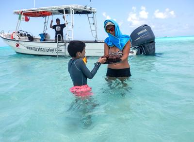 Snorkel trip happy hour, with chocolate cake, fruit, and stingrays underfoot